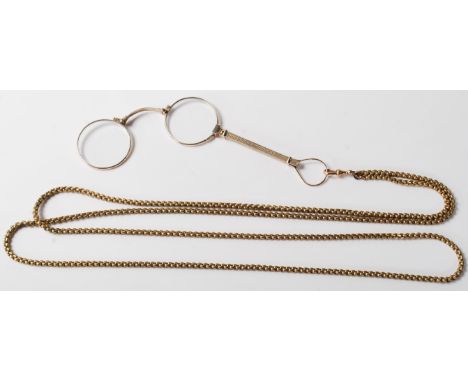 A pair of early 20th Century yellow metal lorgnettes / spectacles opera glasses having an extendable arm with an engine turne