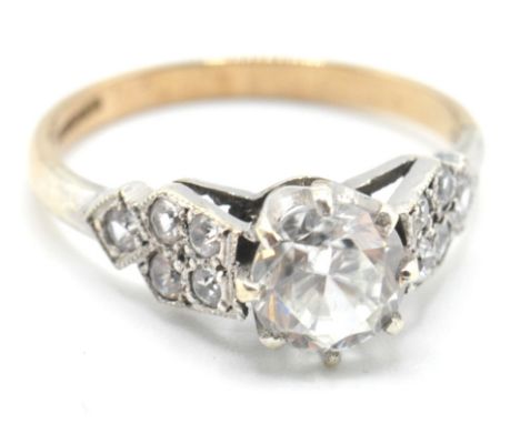 A stamped 9ct gold ring being set with a round cut white stone having white metal shoulders set with further white accent sto