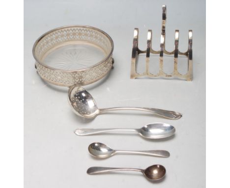 A quantity of early 20th century antique silver items to include a toast rack with hoop handle atop. Hallmarks for Birmingham