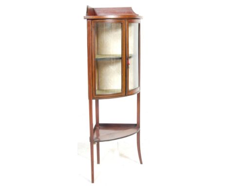 An early 20th Century Edwardian mahogany corner display cabinet having a gallery top with glazed bow front doors with brass e