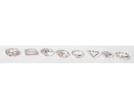 A collection of 8 silver rings to include a silver ring with a repeating dolphin motif, a silver ring with the word Sister, a