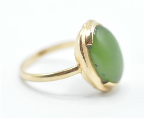 A stamped 14ct gold ring being set with a oval green stone cabochon set within a gold mount. Weight 3.5g. Size K.5.