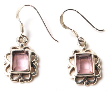A pair of sterling silver and amethyst art deco style earrings having floral edges and a rectangular bezel setting housing th