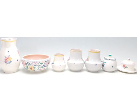 A group of seven vintage Poole Pottery items comprising; a jug, bowl, pair of vases, sugar bowl, lidded pot and a small vase,