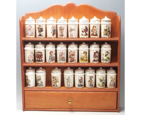 A vintage retro oak spice / herb rack named Little Companions by MJ Hummels for Goebel comprising of a three tiered shelving 