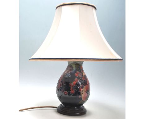 A 20th Century Moorcroft finches pattern table lamp of baluster form being decorated with tube lined fruit and flying birds w