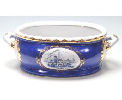 A Staffordshire blue and white ceramic foot bath with twin handles, transfer print panel at the front and rear depicting a gr