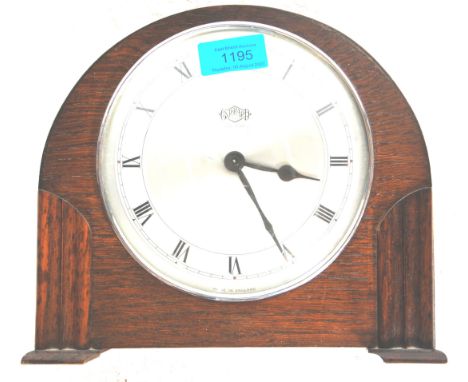 A retro vintage 1930s oak art deco mantel clock by Kemp Brothers having a dome shaped top set on pillar supports with a white