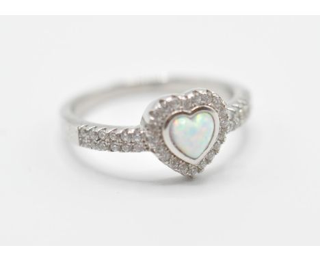 A stamped .925 silver ladies dress ring having a heart shaped opal set within a halo of accent stones and further accent ston