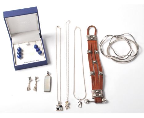 A collection of silver jewellery to include a stamped 925 silver bangle, a stamped 925 wave form bangle, a leather bangle wit