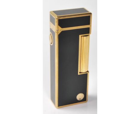 A vintage retro Dunhill lighter having black enamelled panels throughout with gilt borders, roller to the side, and a hinged 