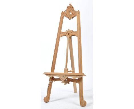 A good 20th century stripped mahogany architectural artists easel of tall folding form having threaded adjustable rest to cen