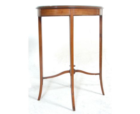 An Edwardian mahogany hall side table having an oval top with a diamond veneer and satinwood inlaid borders raised on taperin