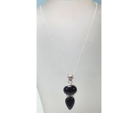 A stamped .925 silver pendant necklace having a silver cable chain with a lobster claw clasp. The pendant has two amethyst st
