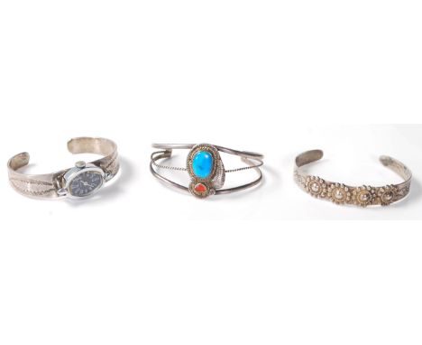 A group of three native American Navajo silver bangle bracelets to include one split band bangle marked RY set with turquoise