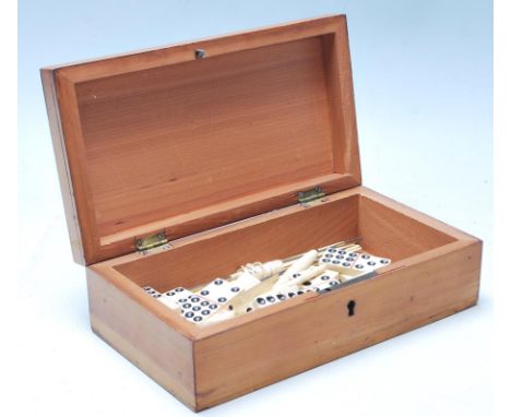 A collection of Victorian bone dominoes pieces together with bone button hooks and other related sewing items in a wooden box