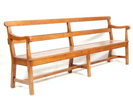 An early 20th century Railway / bus station pew bench with scroll armrest, plank seat, bentwood supports united by stretchers