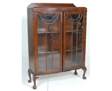 A 1930's Art Deco oak bow front library&nbsp; bookcase cabinet. The cabinet having a raised back over double astragal glazed 