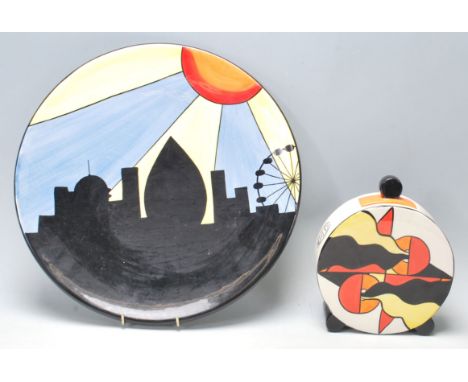 Lorna Bailey ceramic charger plate being hand painted with black, blue, yellow and orange colours, depicting sunburst over Lo