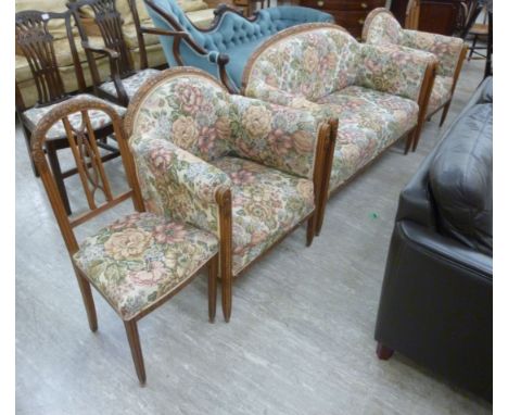 An early 20thC Continental reed moulded, floral and foliate carved walnut showwood framed five piece salon suite  comprising 
