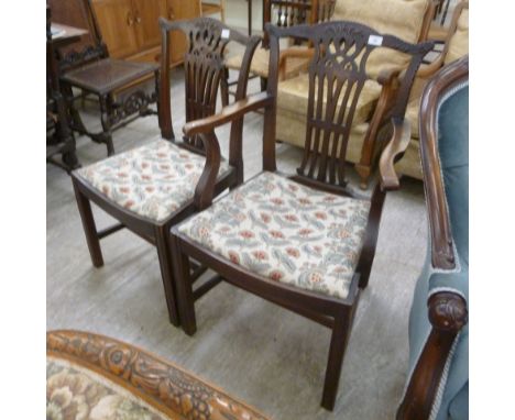 An early 19thC mahogany framed elbow chair, having a carved yoke crest and waisted splat, the open, scrolled arms on shaped s