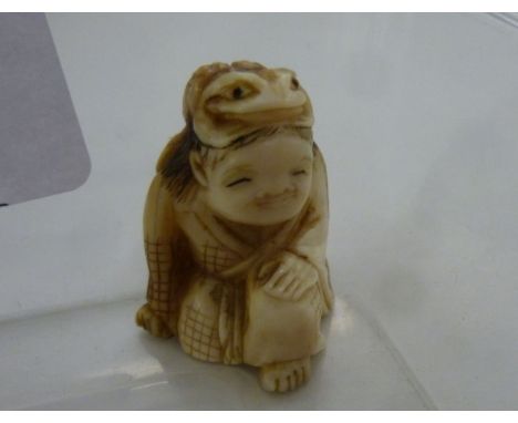 A late 19th/20thC Japanese carved ivory netsuke, a kneeling figure with a toad on his head       11