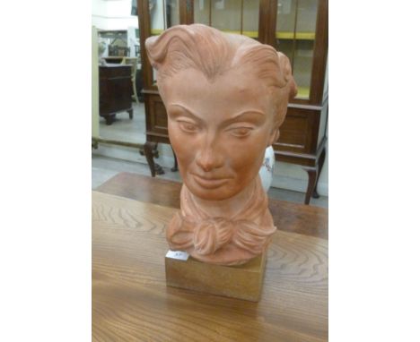 After DM Thropp - a terracotta coloured moulded plaster bust, a young woman wearing a bow-tied scarf  bears an incised signat