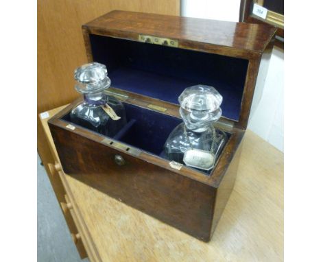 An early 19thC oak tantalus of plain box design, the lockable hinged lid enclosing two facet cut decanters and stoppers with 