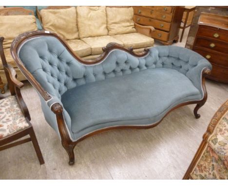 A late Victorian style mahogany floral, foliate and scroll carved, showwood framed settee, having a low, round end, an offset