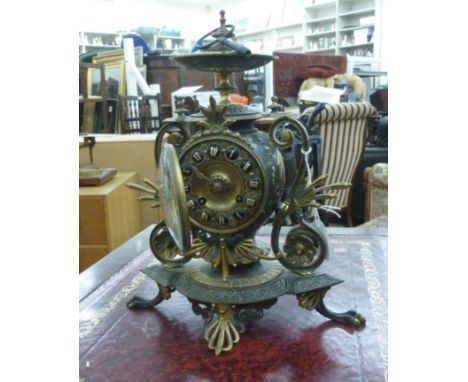 An early 20thC decoratively fashioned, patinated and lacquered gilt metal cased mantel clock; the bell strike movement faced 