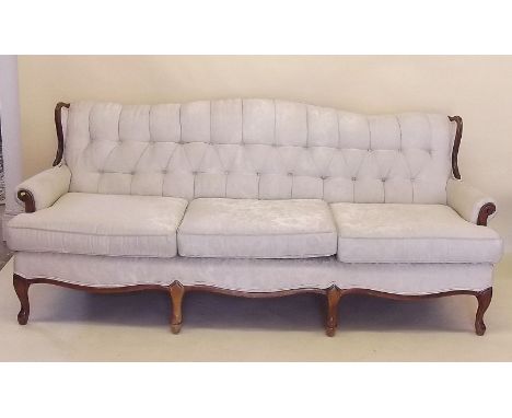 A mahogany framed three seater cream button upholstered settee