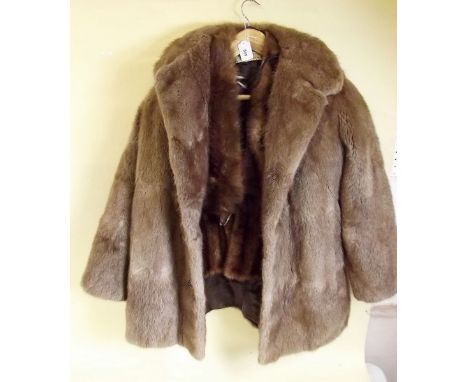 A fur wrap and a light coloured fur jacket and a fox tippet