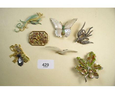 A carved mother of pearl butterfly brooch, two bird brooches, two other vintage brooches and two necklaces