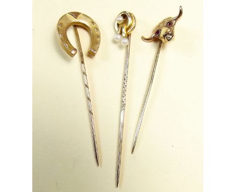 Three stick pins: a 9 carat gold horse shoe one, a 15 carat one set seed pearls, and a bull with ruby eyes - unmarked