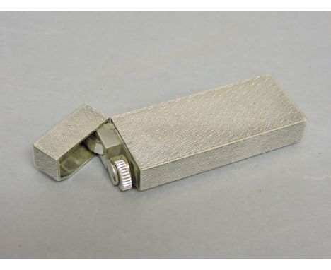 A silver plated Cartier lighter, engraved with geometric pattern, serial number 1A86192, 7cm long
