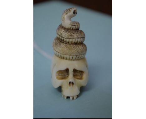 A Japanese carved ivory skull and serpent netsuke,&nbsp;signed, 5cm high. 