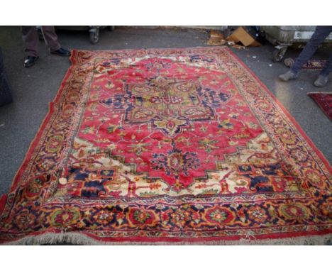 A Persian carpet,&nbsp;having allover floral design with large central medallion, on red ground, 296 x 214cm. 