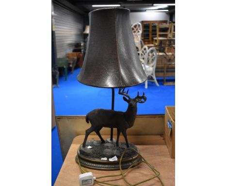 A modern table lamp having a resin cast deer figure and leather shade