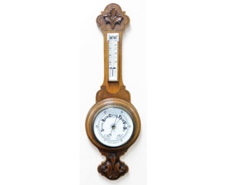 An oak cased aneroid barometer, the top with raised fan and Prince of Wales feather carving, with fahrenheit and centigrade t