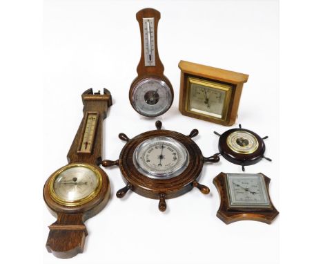 Various oak wall hanging barometers, ships wheel example, small banjo barometer with broken pediment and thermometer and baro
