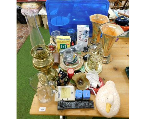 A quantity of ornaments and trinkets, to include a brass oil lamp, posters, two orange urnular glazed vases, mantel clock, te