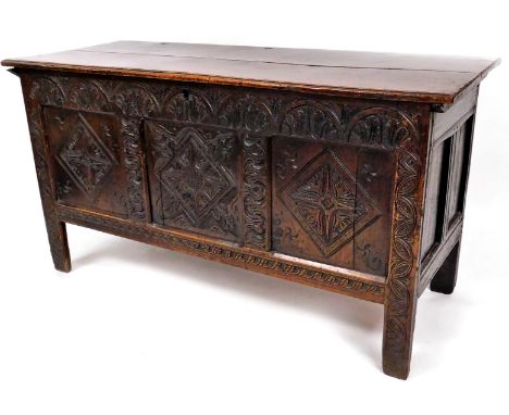 A 17thC oak coffer, with plain two plank top, demi-lune frieze, three front panels with carved lozenges and initials H R 1659