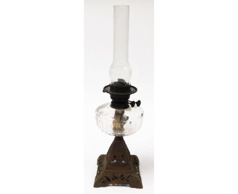 A metal oil lamp, heavy cast metal base, with glass reservoir and chimney, 61cm high.
