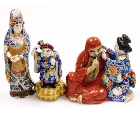 Three various early 20thC porcelain figures, comprising a standing Chinese lady holding scroll, polychrome decorate in blue a