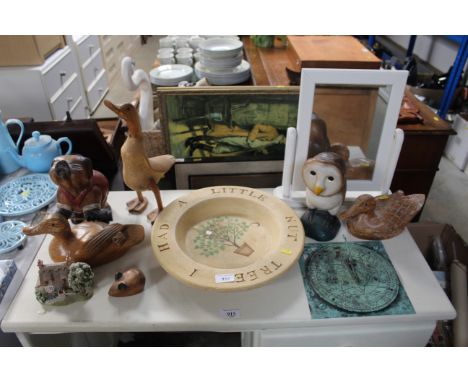 A collection of various wooden duck and other ornaments; a pottery plate and sundial 