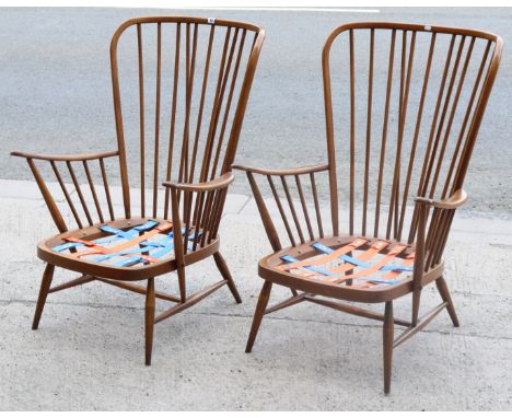 A pair of Ercol spindle-back armchairs (lacking cushions),&nbsp;on round tapered legs with spindle stretchers.
