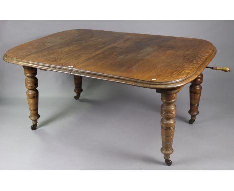 A Victorian oak extending dining table with moulded edge &amp; rounded corners to the rectangular top, with a wind-out action