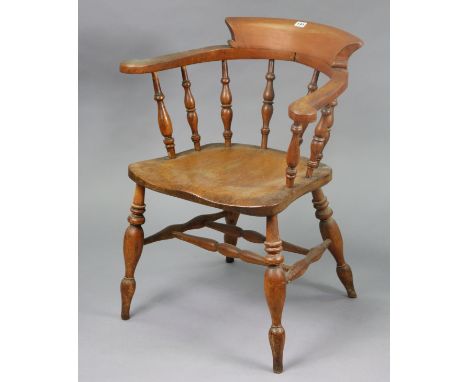 A vintage spindle-back captain’s chair with a hard seat, &amp; on turned legs with spindle stretchers.