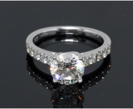 A diamond solitaire ring, the principal four claw set round brilliant cut stone weighing approx. 1.52cts, diamond set shoulde