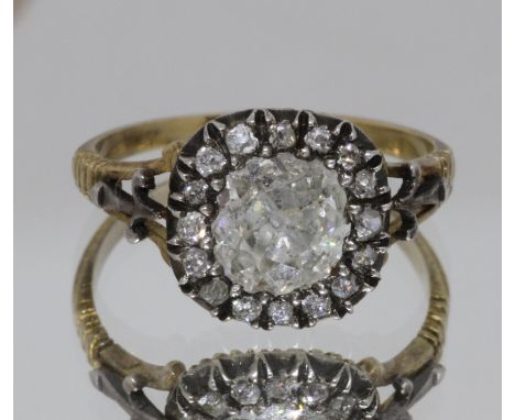 A Georgian diamond cluster ring, the central stone weighing approx. 1ct, surrounded by sixteen melee diamonds, the white meta